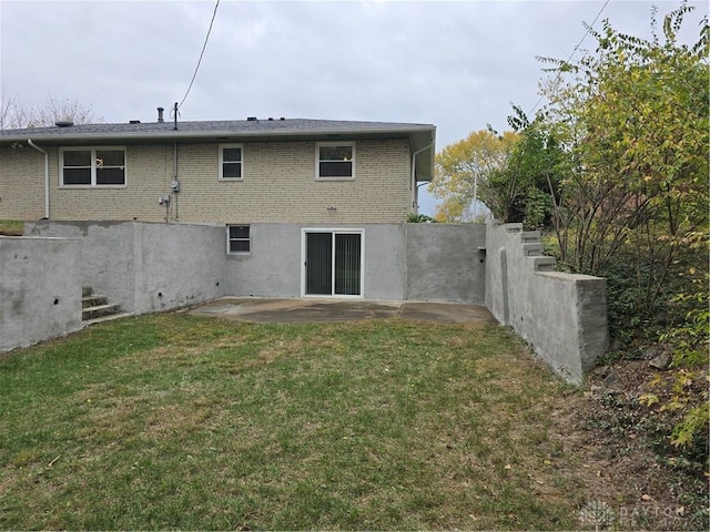 rear view of property with a lawn and a patio area