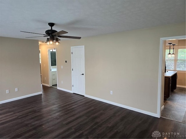 unfurnished room with ceiling fan and dark hardwood / wood-style flooring