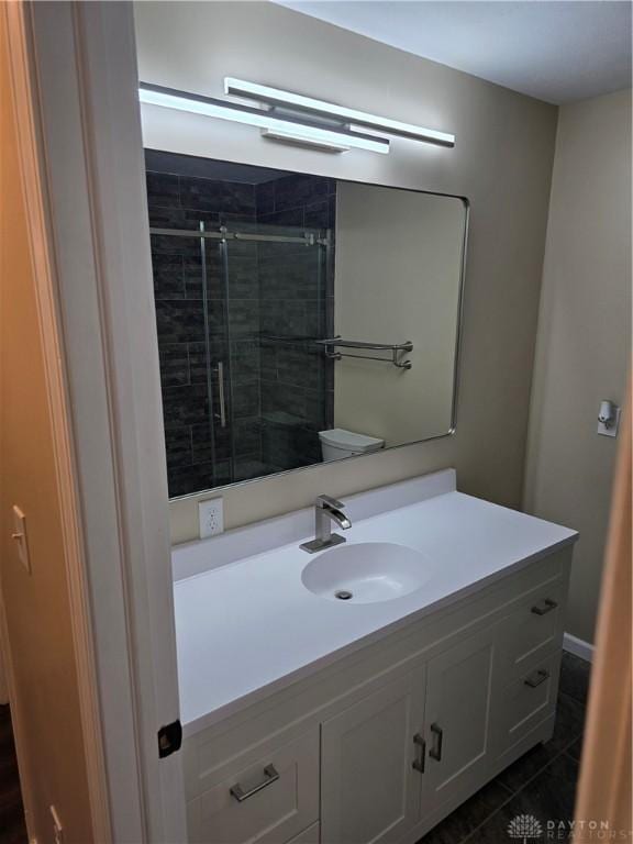 bathroom featuring tile patterned floors, vanity, toilet, and an enclosed shower