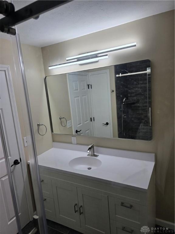 bathroom featuring a shower and vanity