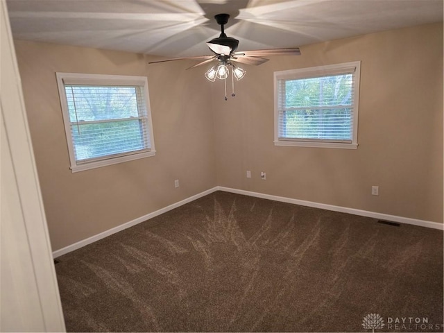 unfurnished room featuring dark colored carpet and ceiling fan