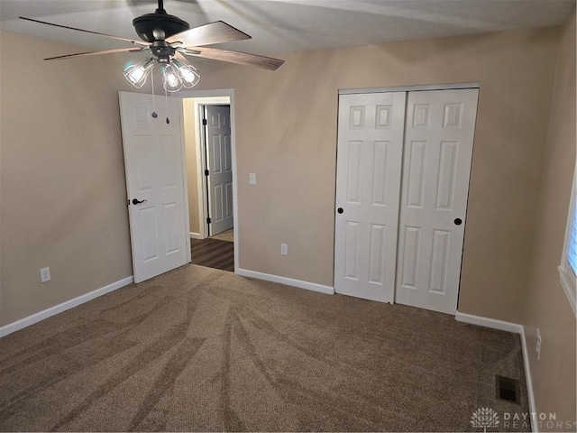 unfurnished bedroom featuring ceiling fan, a closet, and dark colored carpet