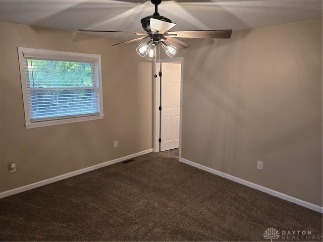 empty room with ceiling fan and dark carpet