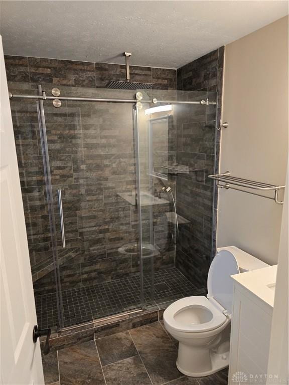 bathroom featuring vanity, toilet, and an enclosed shower