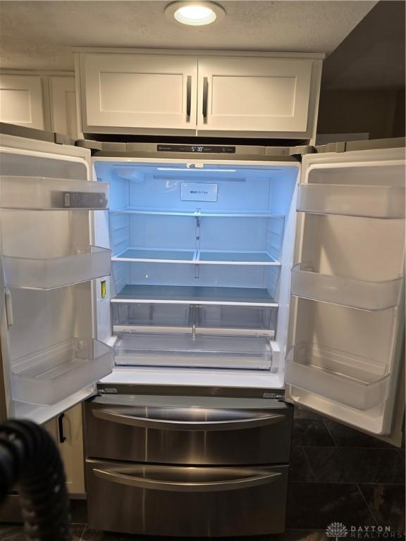 interior details featuring white cabinets and fridge