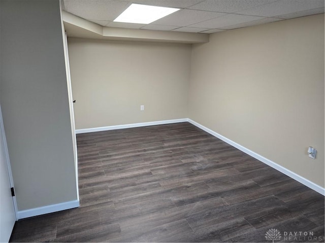 unfurnished room with a paneled ceiling and dark wood-type flooring