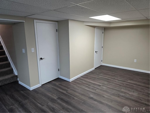 basement featuring dark hardwood / wood-style flooring and a drop ceiling