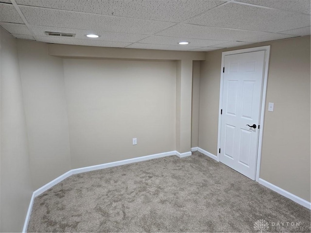 carpeted spare room with a paneled ceiling