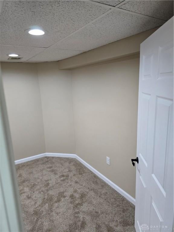 basement featuring carpet and a paneled ceiling