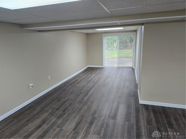 unfurnished room with dark hardwood / wood-style flooring and a drop ceiling