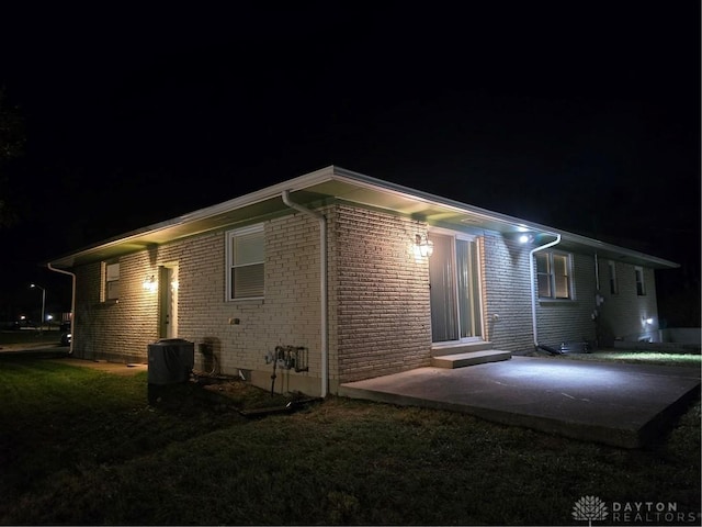 back house at night featuring a patio