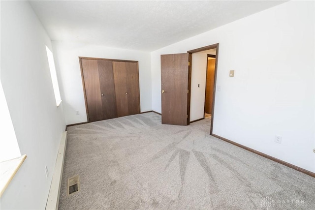 unfurnished bedroom featuring light carpet and a closet