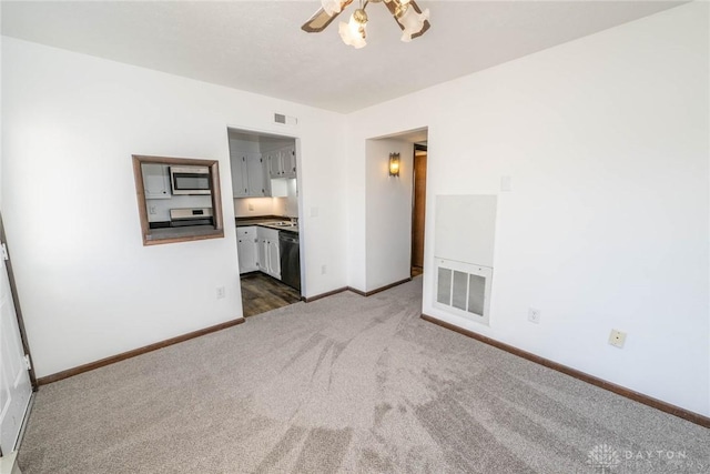 empty room with dark carpet and a chandelier