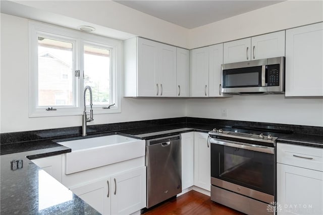 kitchen with dark hardwood / wood-style flooring, sink, white cabinets, and stainless steel appliances