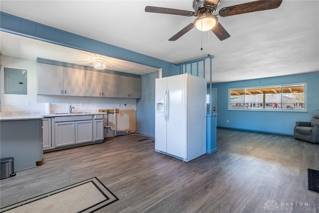 kitchen featuring electric panel, white fridge with ice dispenser, dark wood-type flooring, and sink