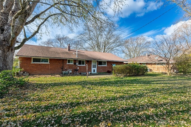 rear view of property featuring a yard