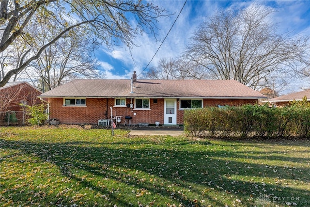 rear view of house with a lawn, central AC unit, and a patio