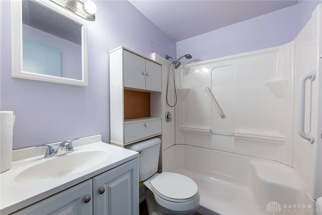 bathroom featuring toilet, vanity, and walk in shower