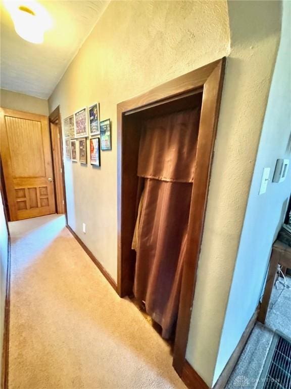 hall featuring carpet flooring and lofted ceiling