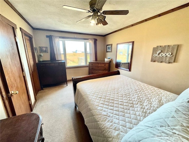 carpeted bedroom with a textured ceiling, ceiling fan, and crown molding