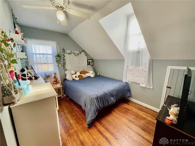 bedroom with ceiling fan, lofted ceiling, and hardwood / wood-style flooring