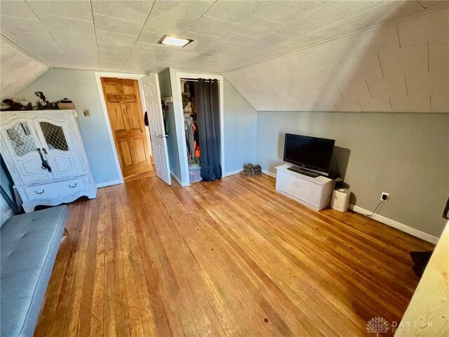 unfurnished living room with light hardwood / wood-style floors and lofted ceiling