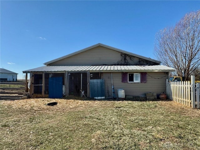 back of house with an outdoor structure and a lawn