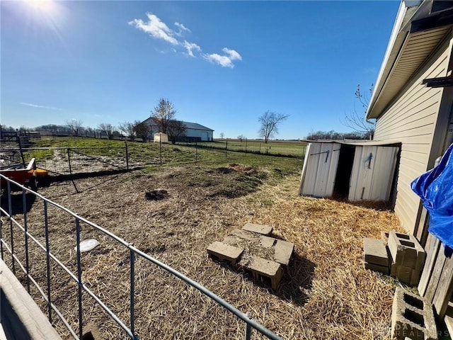 view of yard with a rural view and a storage unit