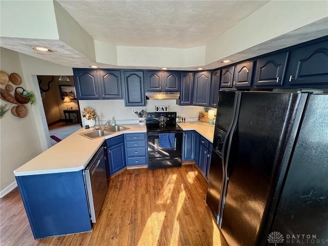 kitchen with sink, light hardwood / wood-style flooring, black appliances, blue cabinets, and kitchen peninsula