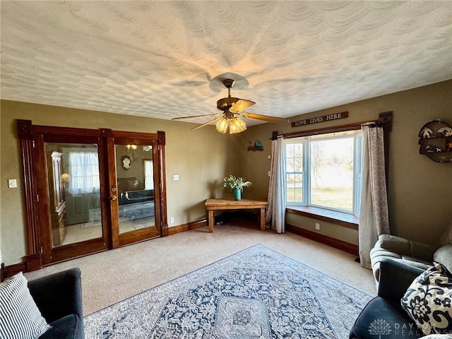 sitting room with light carpet, ceiling fan, and a textured ceiling