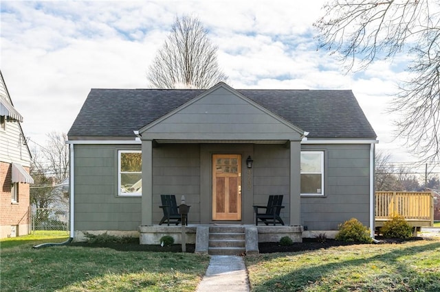 bungalow-style home featuring covered porch and a front lawn