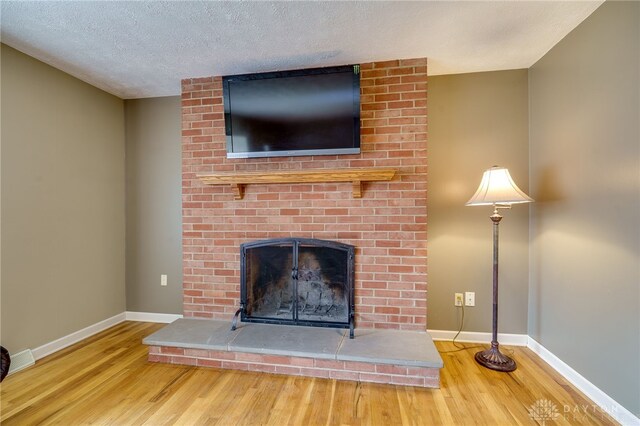 details featuring a fireplace, wood-type flooring, and a textured ceiling