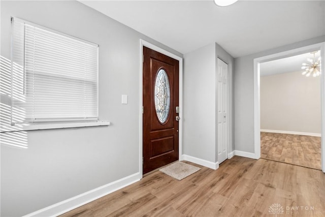 foyer entrance featuring light hardwood / wood-style flooring and a notable chandelier