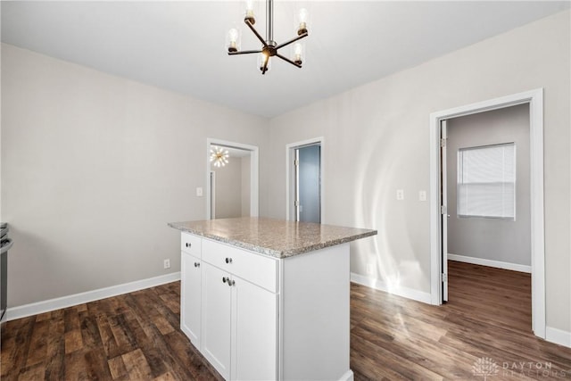 kitchen featuring a kitchen island, pendant lighting, a notable chandelier, dark hardwood / wood-style floors, and white cabinetry