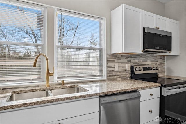 kitchen featuring backsplash, sink, white cabinets, and appliances with stainless steel finishes