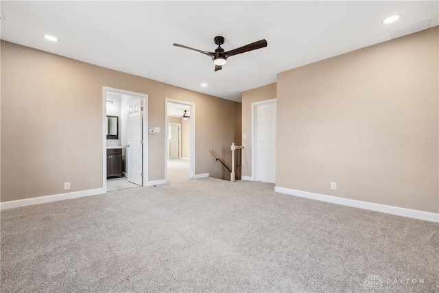 unfurnished bedroom featuring ensuite bathroom, ceiling fan, and light carpet