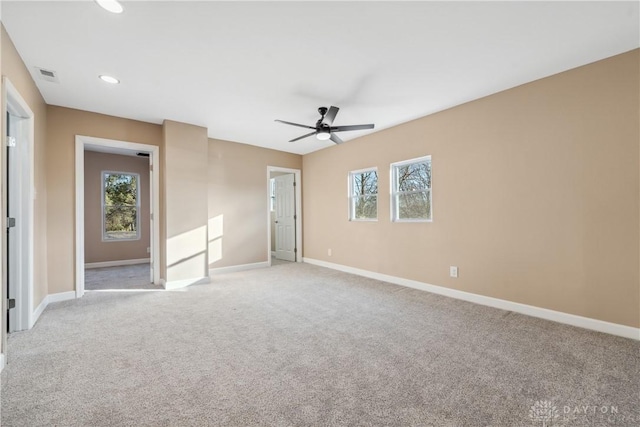 carpeted empty room with plenty of natural light and ceiling fan