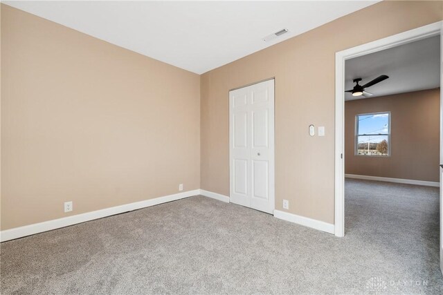 unfurnished bedroom with ceiling fan, a closet, and light colored carpet