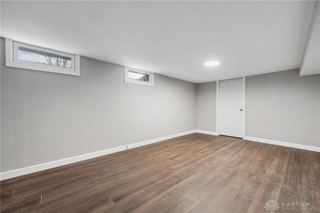 basement featuring a healthy amount of sunlight and dark wood-type flooring