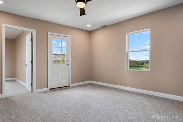 empty room featuring ceiling fan, baseboards, carpet flooring, and visible vents