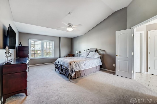 bedroom with ceiling fan, light colored carpet, and vaulted ceiling