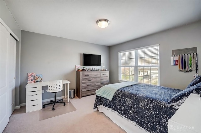 bedroom featuring light colored carpet and a closet