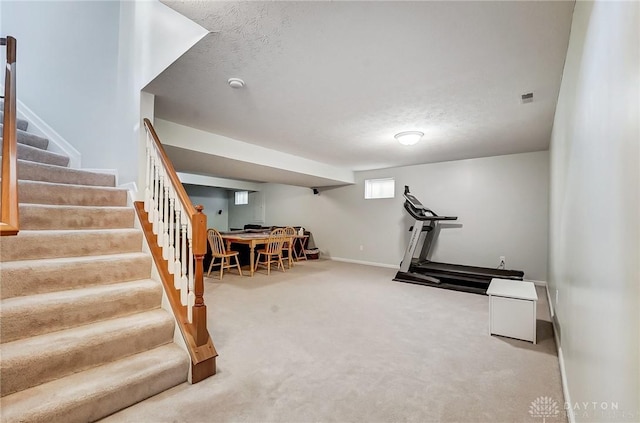 exercise room featuring carpet flooring and a textured ceiling