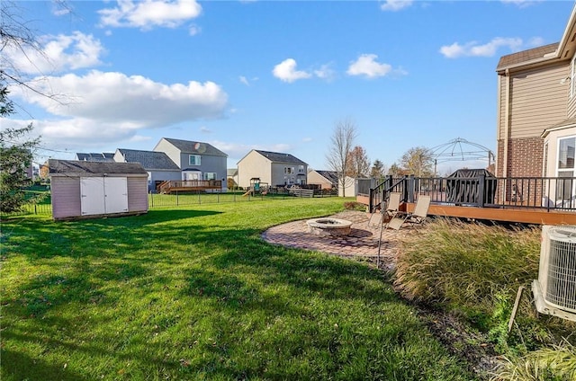 view of yard featuring central AC, a shed, a deck, and an outdoor fire pit