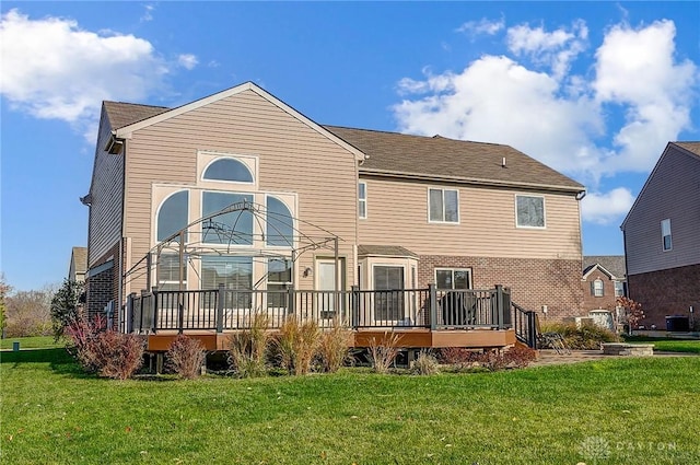 back of house featuring central air condition unit, a lawn, and a wooden deck