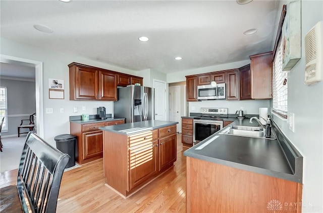 kitchen featuring a center island, sink, light wood-type flooring, and stainless steel appliances