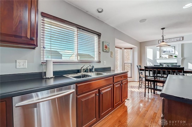 kitchen with a wealth of natural light, sink, stainless steel dishwasher, and light hardwood / wood-style floors