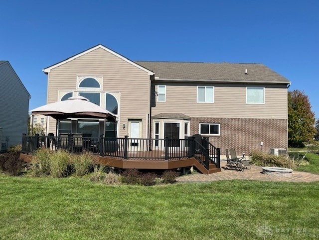 rear view of house with a gazebo, a fire pit, a deck, and a yard