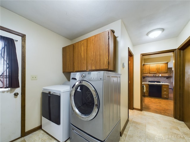 clothes washing area with cabinets, separate washer and dryer, and light hardwood / wood-style floors