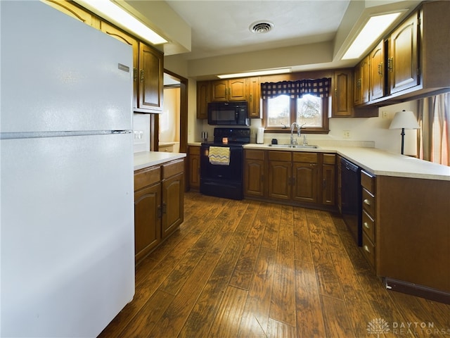 kitchen featuring sink, dark wood-type flooring, and black appliances